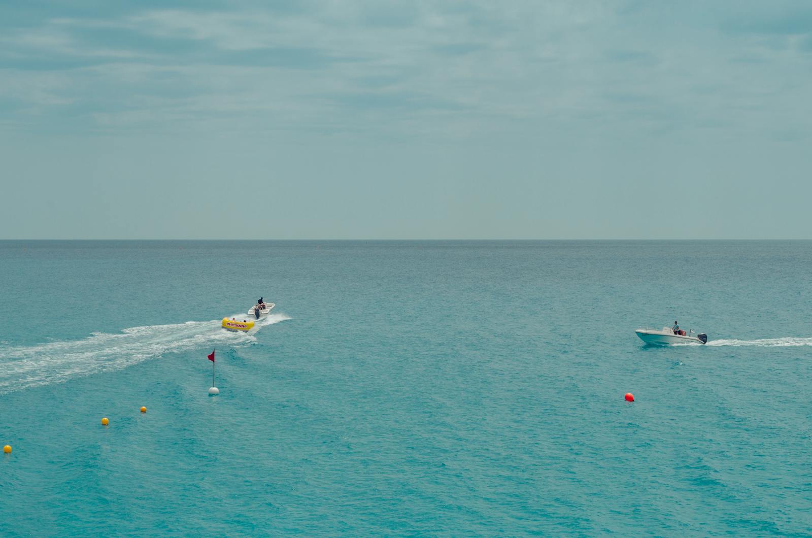 Two People Rides Watercrafts On Body Of Water Under Clear Blue Sky