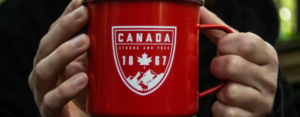 person holding red metal mug