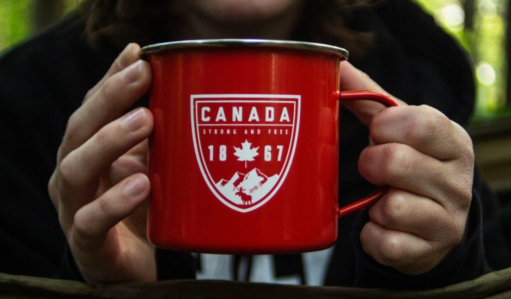 person holding red metal mug